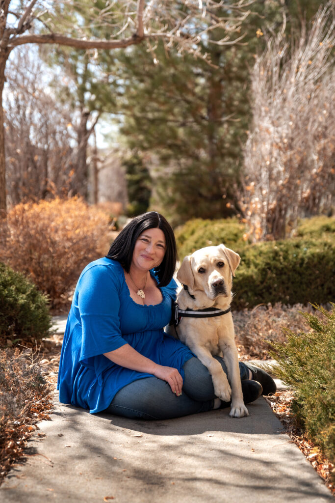 Woman sitting with Service Dog in park